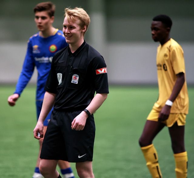 Dommer og to fotballspillere på banen